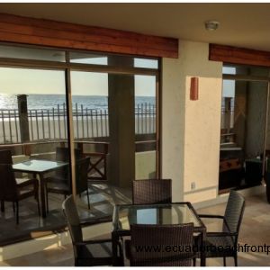 Spacious beachfront patio with dining table and chairs plus two comfy chairs with ottomans