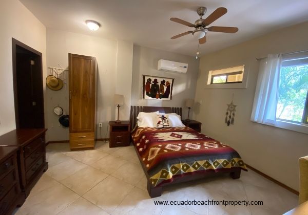 Master bedroom with queen bed, desk, overhead fan and AC.
