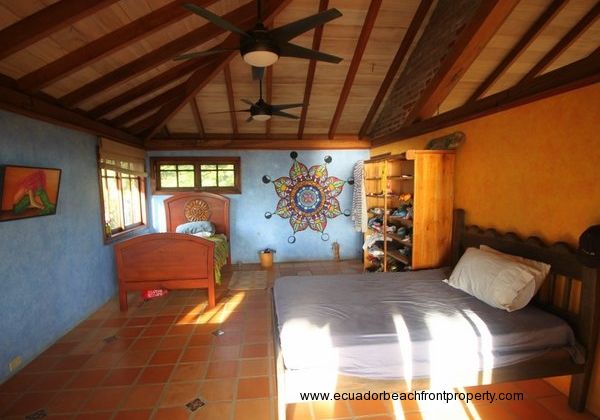 Spacious upstairs bedroom with vaulted wood ceiling and painted mandala