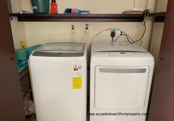 Laundry area with washer and dryer and shelving area.