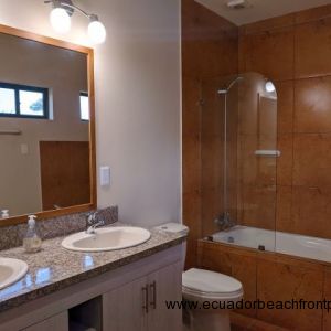 Full bath with double sinks and a bath tub.