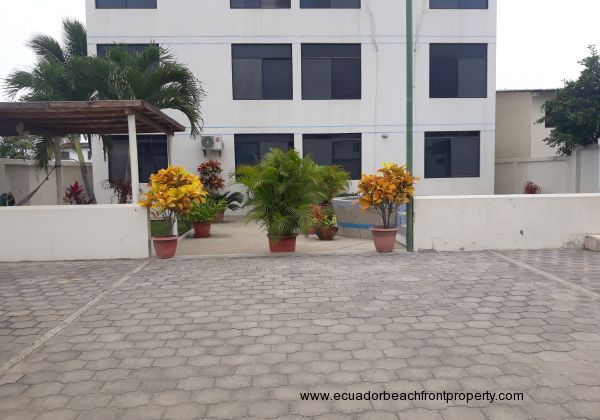 A view from the car park gate to the garden / patio / pool area at the back of the condo building.