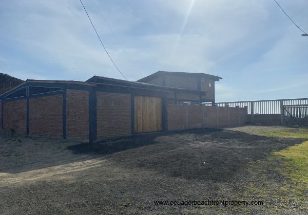 View of the house from outside the property boundry but inside the wlled area of the 4 properties, 2 houses and 2 lots.