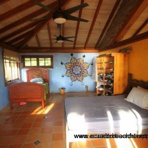 Spacious upstairs bedroom with vaulted wood ceiling and painted mandala