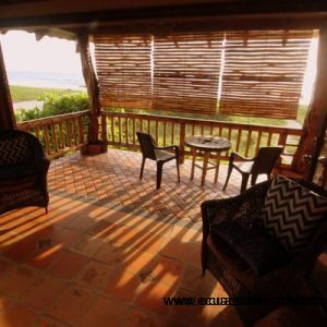 Sitting area of the master bedroom with bamboo sun shade lowered against the setting sun