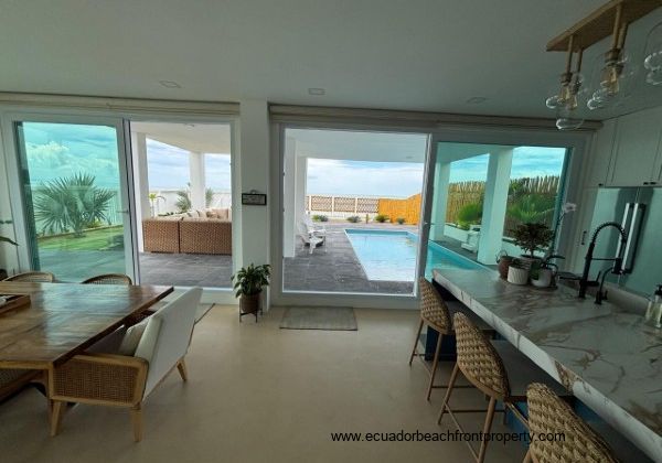 The kitchen and dining area lead to a large covered patio with a pool 