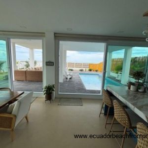 The kitchen and dining area lead to a large covered patio with a pool 